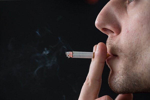 a man smoking a cigarette - how it affects your heart